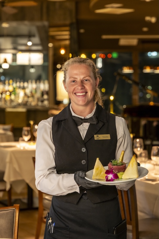 Server presenting the sesame seared tuna appetizer at Empire Steak House Hawaii
